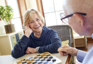 Two senior residents playing checkers